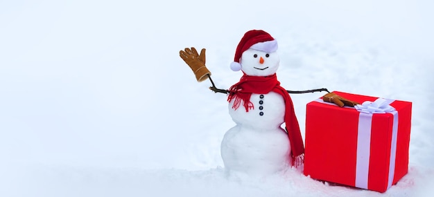 Snowmanin santa hat i szalik z prezentem świąteczny bałwan na białym tle śniegu bałwan backgroun
