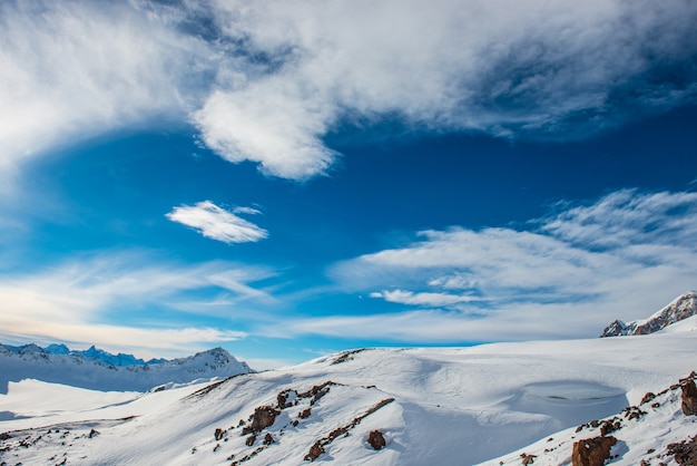 Snowy błękitne góry w chmurach. Zimowy ośrodek narciarski