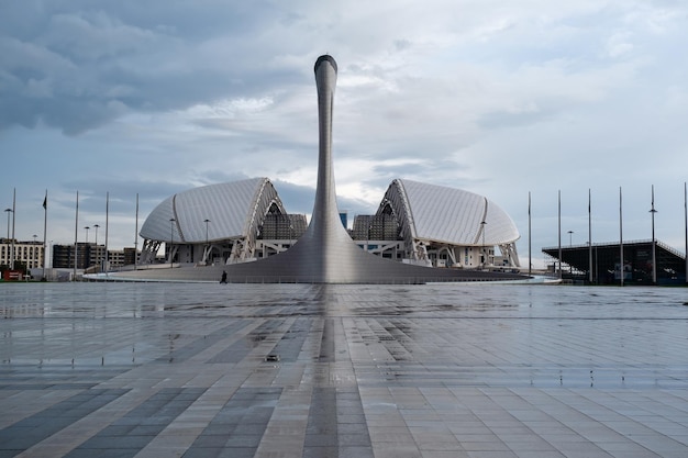 SOCHI ADLER ROSJA 13 kwietnia 2023 Pochodnia olimpijska i stadion Fisht w widoku z przodu parku olimpijskiego