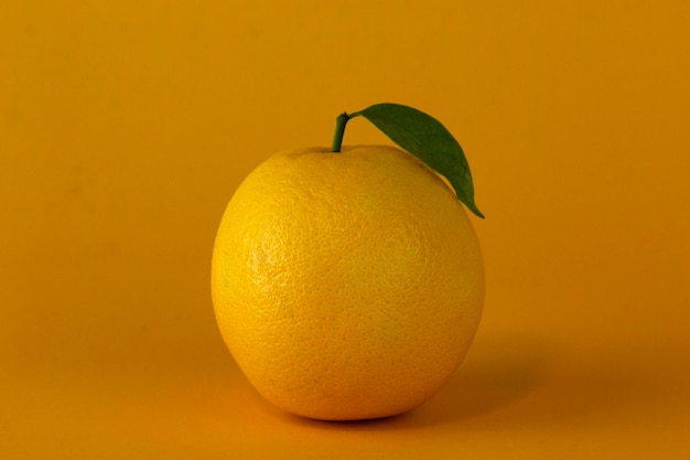 Soczysta cytryna na żółtym tle Cytryna używana do projektowania koncepcji zdrowych owoców Pomarańczowe owoce z pomarańczowymi plasterkami i liśćmi na żółtym tle