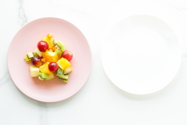 Soczysta sałatka owocowa na śniadanie na marmurowej diecie flatlay i koncepcji zdrowego stylu życia