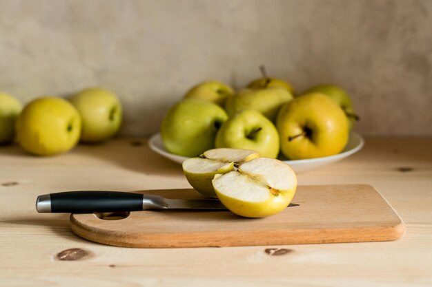 Soczyste, świeże, żółte jabłka z kroplami wody w nożu talerzowym do krojenia jabłek