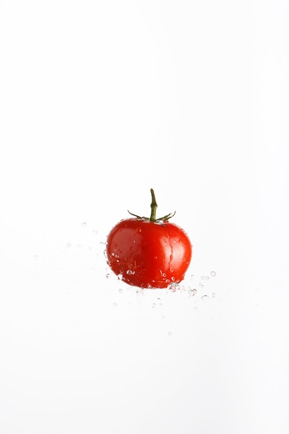 Zdjęcie soczysty czerwony pomidor w sprayu wody