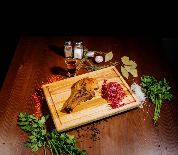 Soczysty kawałek smażonego mięsa leży na desce do krojenia na drewnianym stole.