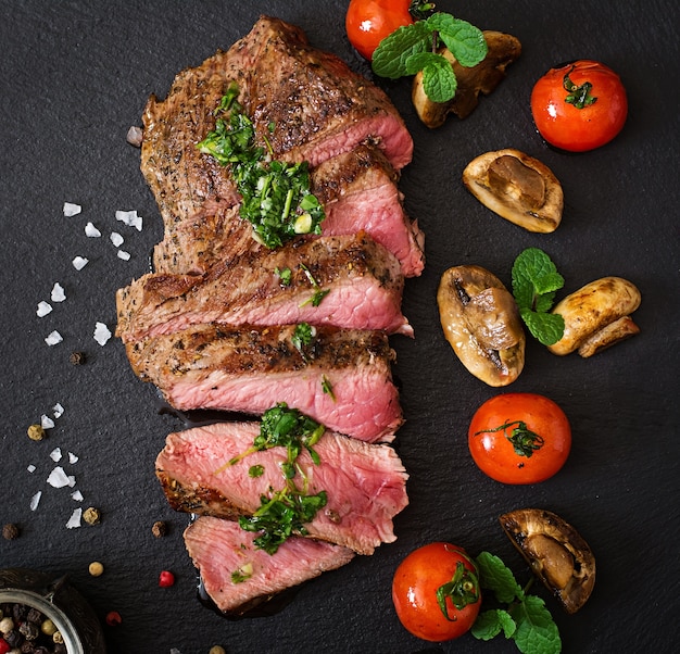 Soczysty stek średnio rzadko wołowina z przyprawami i warzywami z grilla. Widok z góry