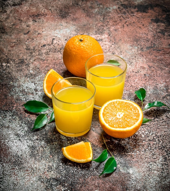 Sok pomarańczowy w szklance świeżych pomarańczy