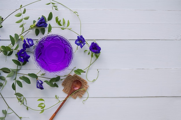 Sok z kwiatów Anchan lub herbata ziołowa z niebieskiego groszku, groszek motylkowy w szklanym kubku z drewnianą łyżką.