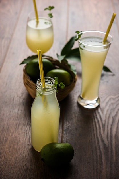 Sok z mango LUB Aam Panna lub Panha w przezroczystej szklance z całymi zielonymi owocami, selektywne skupienie