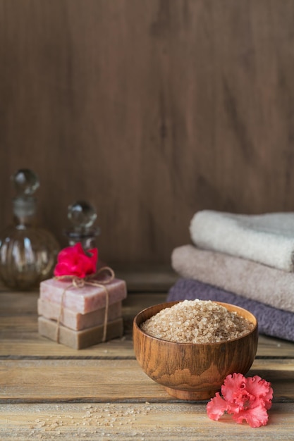 Sól morska naturalne ręcznie robione mydło naturalny olej kosmetyczny i kolorowe ręczniki z kwiatami azalii na rustykalnym drewnianym tle