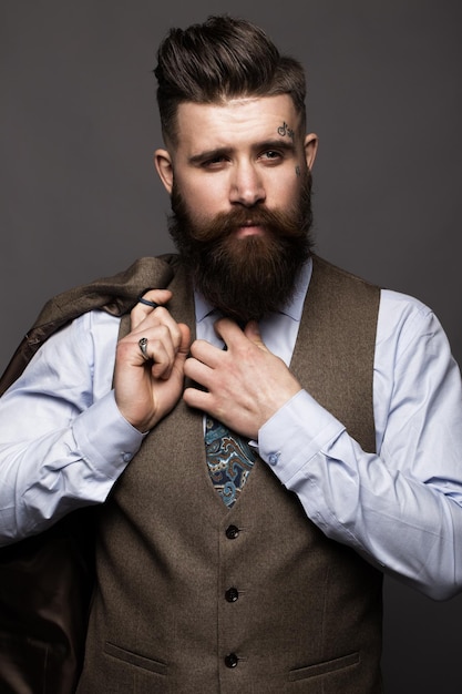 Zdjęcie solidny mężczyzna z brodą i wąsami w klasycznym modnym garniturze