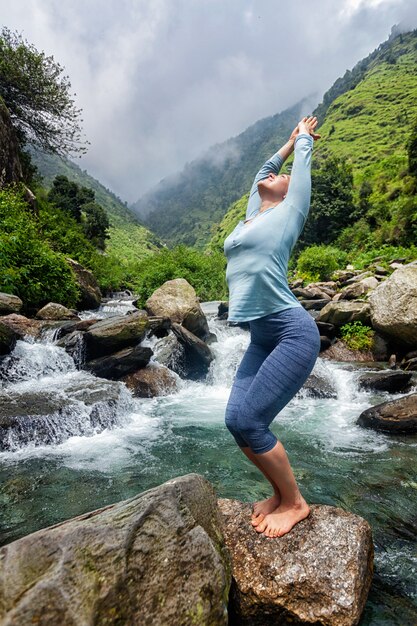Sorty pasuje kobieta robi joga asana w wodospad