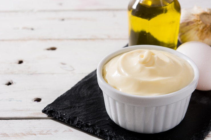 Zdjęcie sos aioli i składniki na biały drewniany stół