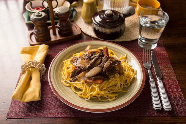 Sos do spaghetti huancaina i lomo saltado Peru peruwiańska żywność komfortowa mise en place drewniany stół