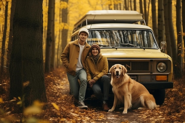 Spacerująca para z psami wśród jesiennych właścicieli lasów ze złotym labradorem relaksującym się w pobliżu samochodu