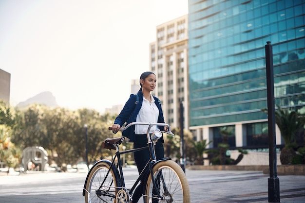 Spacery transportowe i bizneswoman z rowerem w mieście rano i na ulicy do rutyny pracy Ekologiczne podróże i profesjonalna pracownica dojeżdżająca do biura z rowerem w mieście miejskim