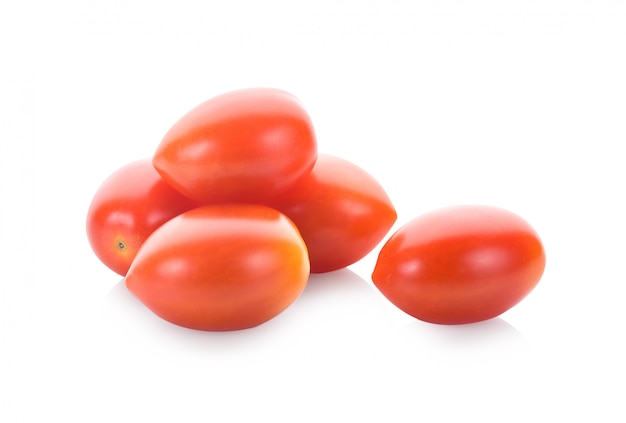 Zdjęcie spadające śliwkowe pomidory na białym tle na białej ścianie