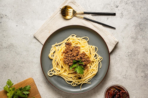 Spaghetti Bolognese w szarym talerzu na szarym tleSpaghetti Bolognese