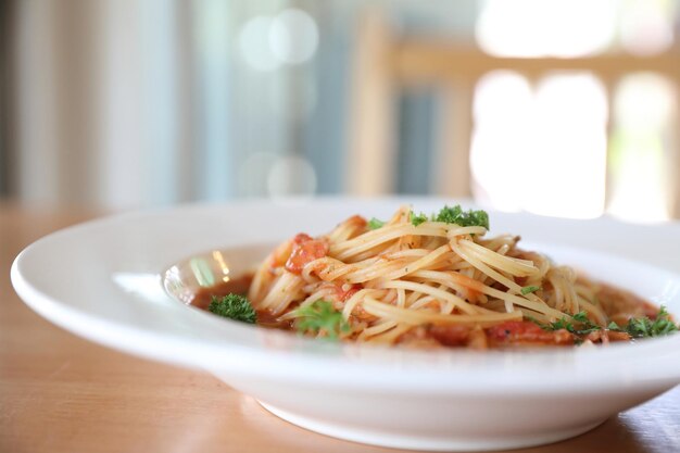 Spaghetti Bolognese z mieloną wołowiną i sosem pomidorowym ozdobione parmezanem i bazylią , włoskie jedzenie