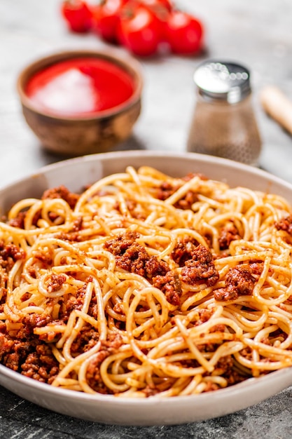 Spaghetti bolognese z pomidorkami koktajlowymi na stole