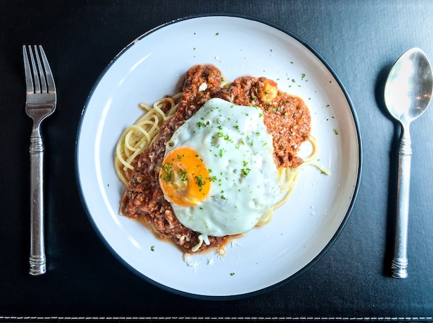 Spaghetti Bolognese z siekaną wołowiną i jajkiem sadzonym z łyżką i folią gotową do spożycia