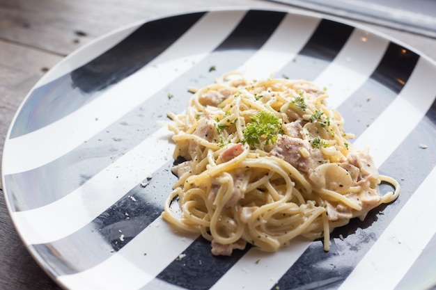 Spaghetti carbonara na białym i czarnym pucharze