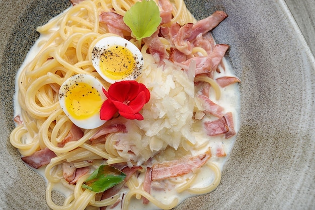 Spaghetti Carbonara na talerzu na ciemnym tle