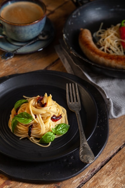 Spaghetti, Kiełbasa Mięsna, Papryka Chili Na Patelni, Czarny Okrągły Talerz Z Włoskim Makaronem Z Warzywami, Liście Bazylii