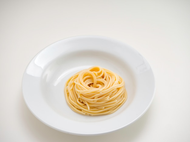 Spaghetti, makaron na talerzu na białym tle