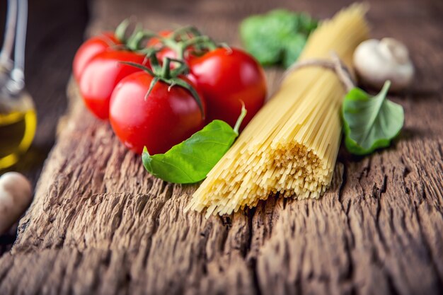 Spaghetti pomidory bazylia oliwa parmezan i pieczarki na bardzo starej dębowej desce