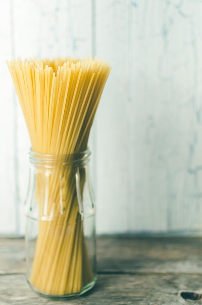 Spaghetti w szklanym słoju na jasnym tle