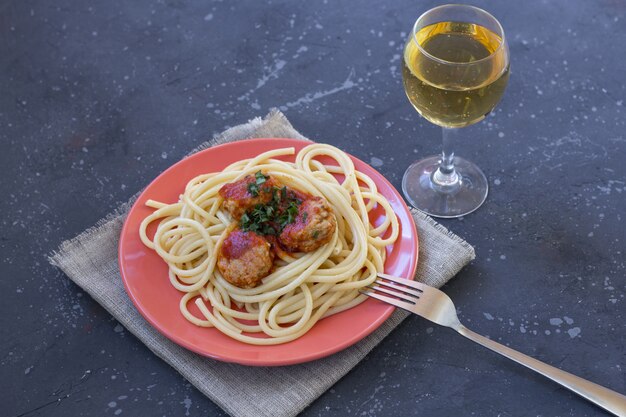 Spaghetti Z Klopsikami I Sosem Pomidorowym W Czerwonym Talerzu Na Ciemnym Tle