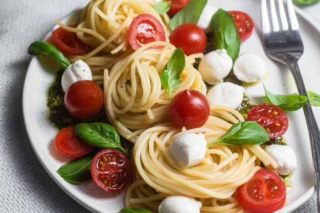 Spaghetti z mozzarellą, pomidorami, bazylią i sosem pesto, makaron Caprese