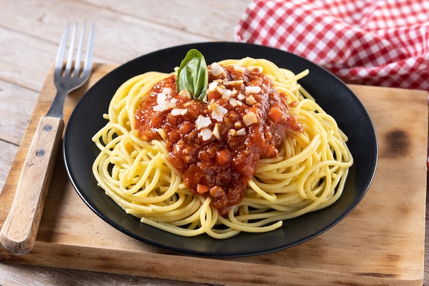 Spaghetti z sosem bolognese na drewnianym stole