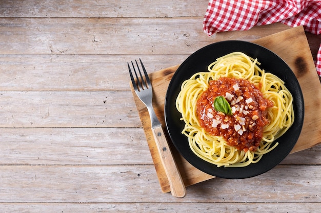 Spaghetti z sosem bolognese na drewnianym stole