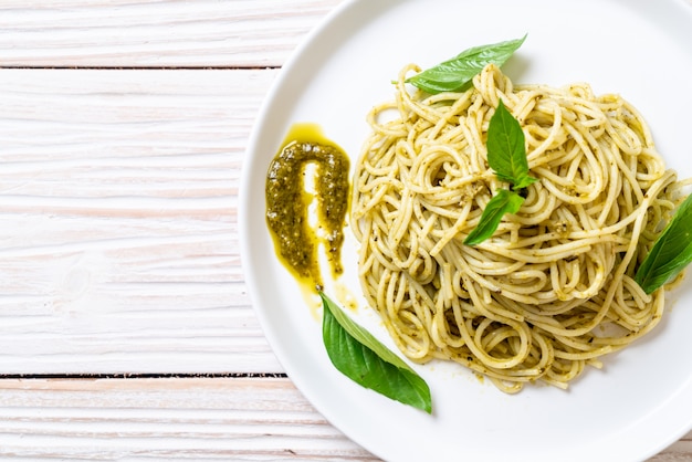 spaghetti z sosem pesto, oliwą z oliwek i liśćmi bazylii.