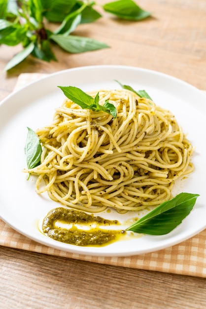 spaghetti z sosem pesto, oliwą z oliwek i liśćmi bazylii.