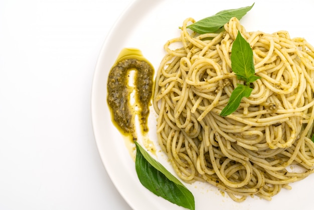 spaghetti z sosem pesto, oliwą z oliwek i liśćmi bazylii.