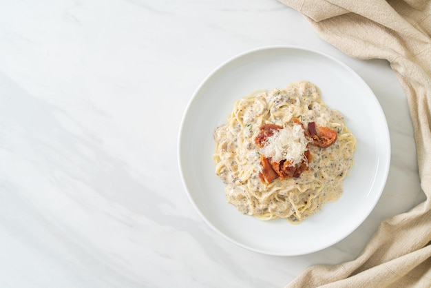 spaghetti z sosem truflowo-śmietanowym i grzybami na talerzu