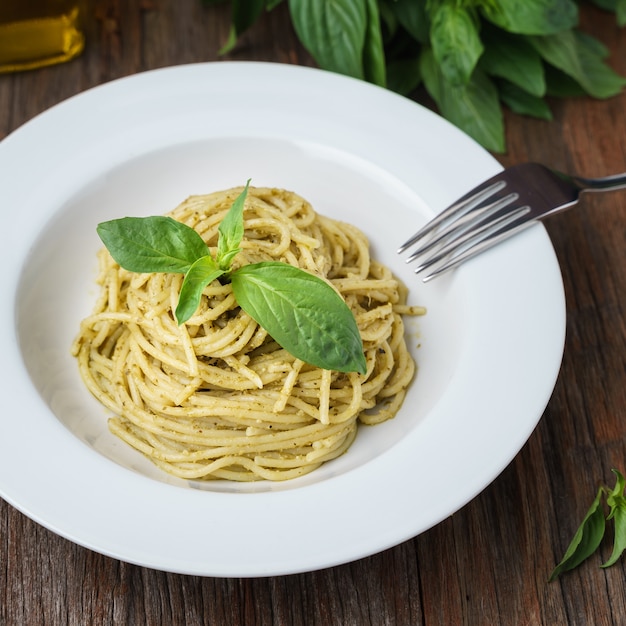 Spaghetti z sosem włoskim pesto w białym naczyniu