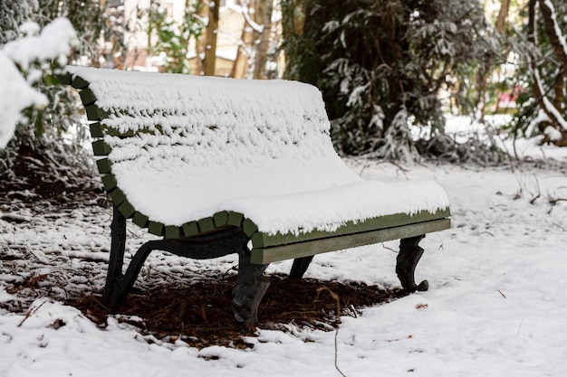 Spakuj ławkę pod śniegiem, gdy śnieg nadal pada, aby uzyskać zimową scenę