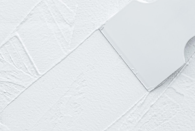 Zdjęcie spatula nakładająca biały kład na ścianę kopiowania przestrzeni