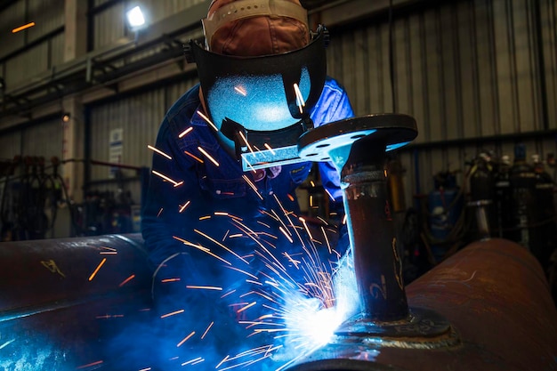 Spawanie metalu męskiego pracownika jest częścią budowy rurociągów dysz maszynowych ropa naftowa i gaz