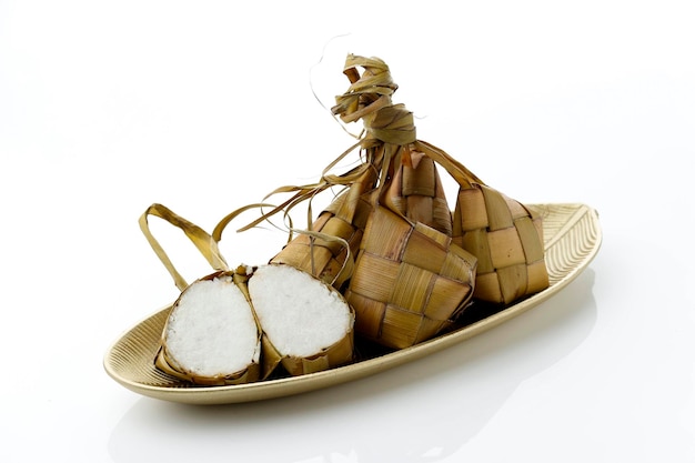 Specjalne danie Ketupat podawane podczas obchodów Eid Mubarak lub Ied Fitr w Indonezji Ketupat to rodzaj knedla zrobionego z ryżu zapakowanego w pojemnik w kształcie rombu z plecionego woreczka z liści palmowych