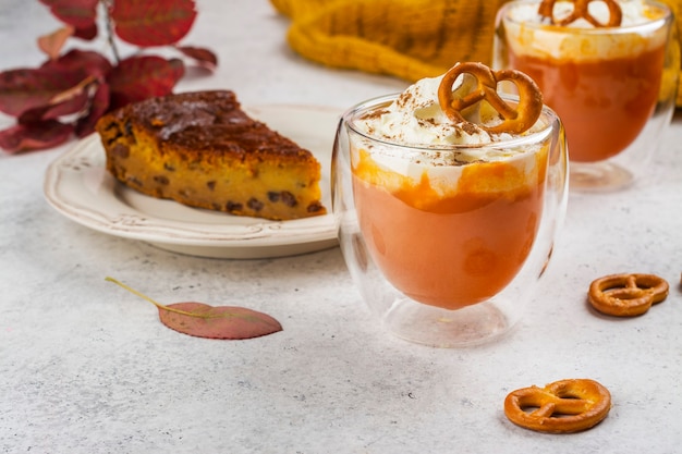 Spice pumpkin pie pomarańczowy napój latte z cynamonem, śmietaną i ciasteczkiem precelkowym.