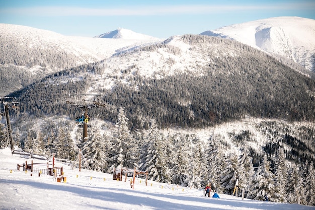 SPINDLERUV MLYN, REPUBLIKA CZESKA - 05.02.2023 Kolejka linowa i narciarze na szczycie góry.