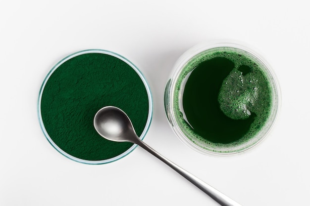 Spirulina w proszku Spirulina rozcieńczona w wodzie Zielony napój w szklance Łyżeczka Spirulina superfood biododatek Green Eco