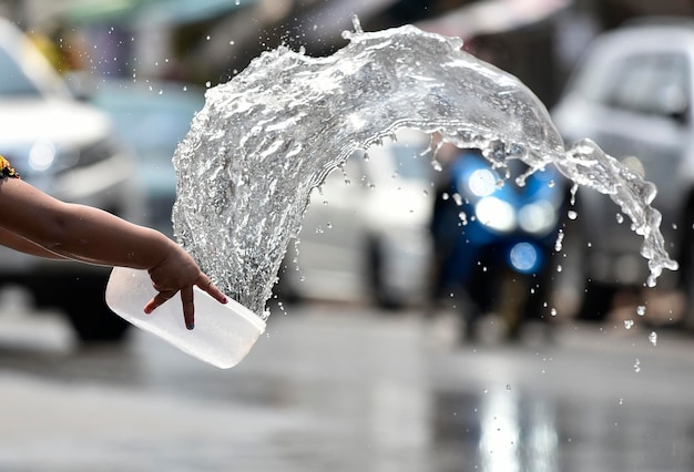 Splash strumień z białej plastikowej miski na wodę na festiwalu Songkran, Tajlandia