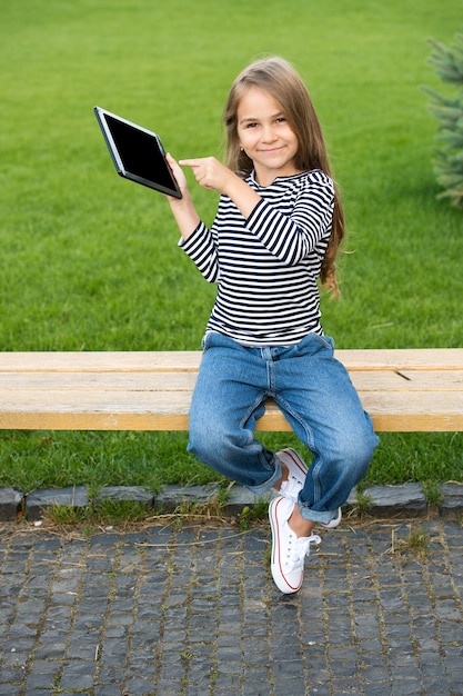 Spójrz na ekran Szczęśliwa dziewczyna palcem wskazującym na tablecie Tablet PC Nowoczesny tablet Technologia ekranu dotykowego
