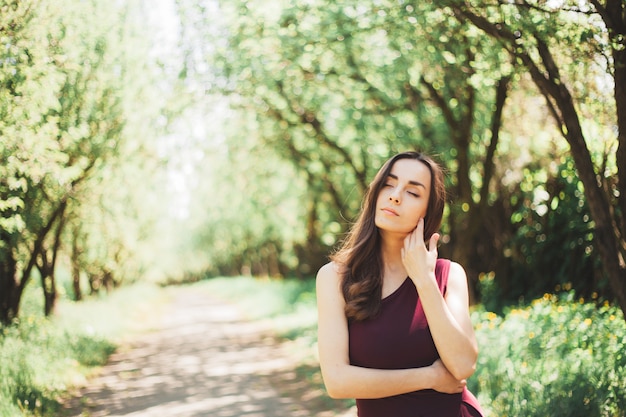 Spokojna Wspaniała Młoda Brunetka W Stylowej Sukience Spaceruje I Pozuje W Letnim Ogrodzie