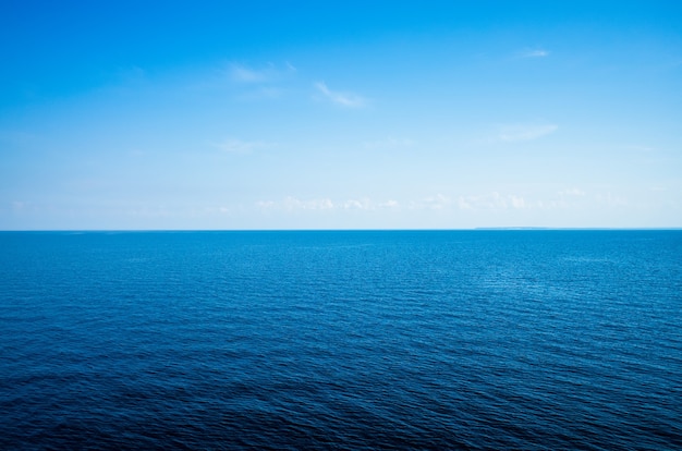 Spokojny minimalistyczny krajobraz z gładką, błękitną powierzchnią morza ze spokojną wodą i czystym niebem